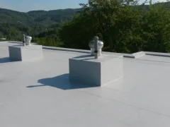 Dvě rotační větrací hlavice těsně u sebe, hory v pozadí