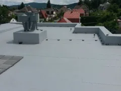 Roh ploché střechy s boxem a rotační hlavicí, podél atiky pruh kačírku